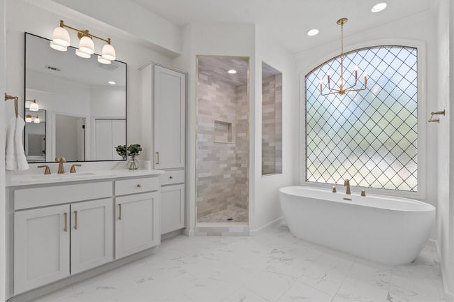 Full bath featuring a soaking tub, vanity, marble look tiles, recessed lighting, and tiled shower | Image 22