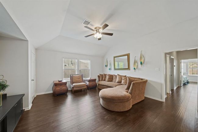 Natural light floods the game room through dual windows, highlighting the beautiful wood flooring and open layout that connects easily to the upstairs bedrooms. | Image 33