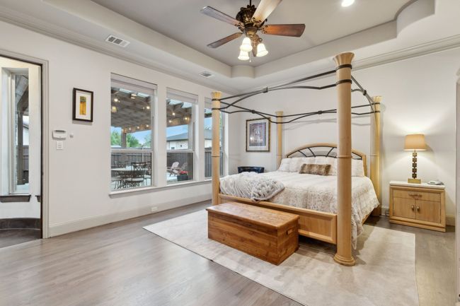 Oak hardwood finished floors, blackout shades, crown molding, and a raised ceiling | Image 11