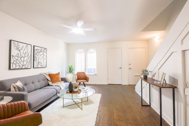 Living area with dark engineered hardwood floors and ceiling fan. | Image 20