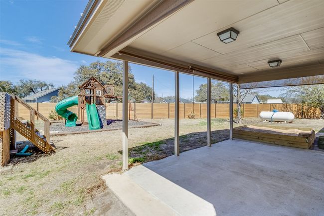 View of patio with a playground and a fenced backyard | Image 30