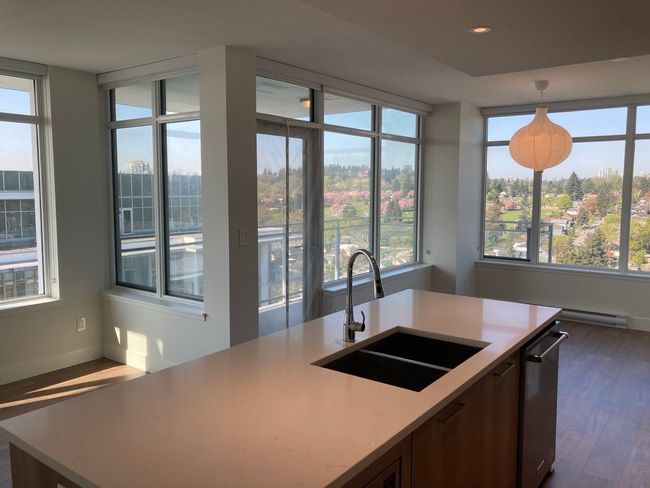 Kitchen with dark wood finished floors, stainless steel dishwasher, a sink, pendant lighting, and baseboards | Image 7