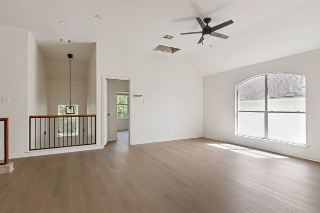 Empty room featuring wood finished floors, a ceiling fan, and high vaulted ceiling | Image 25