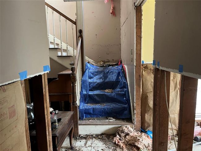 The stairs lead up to the main living area. There has been a roof leak here. | Image 29
