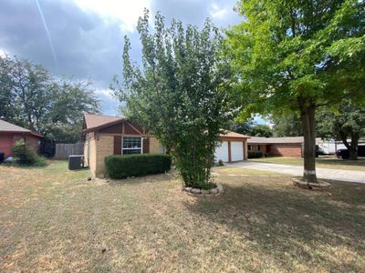 View of front of home featuring cooling unit, a front lawn, and a garage | Image 3