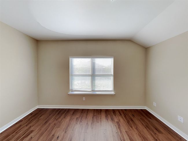 Empty room with wood finished floors and lofted ceiling | Image 12