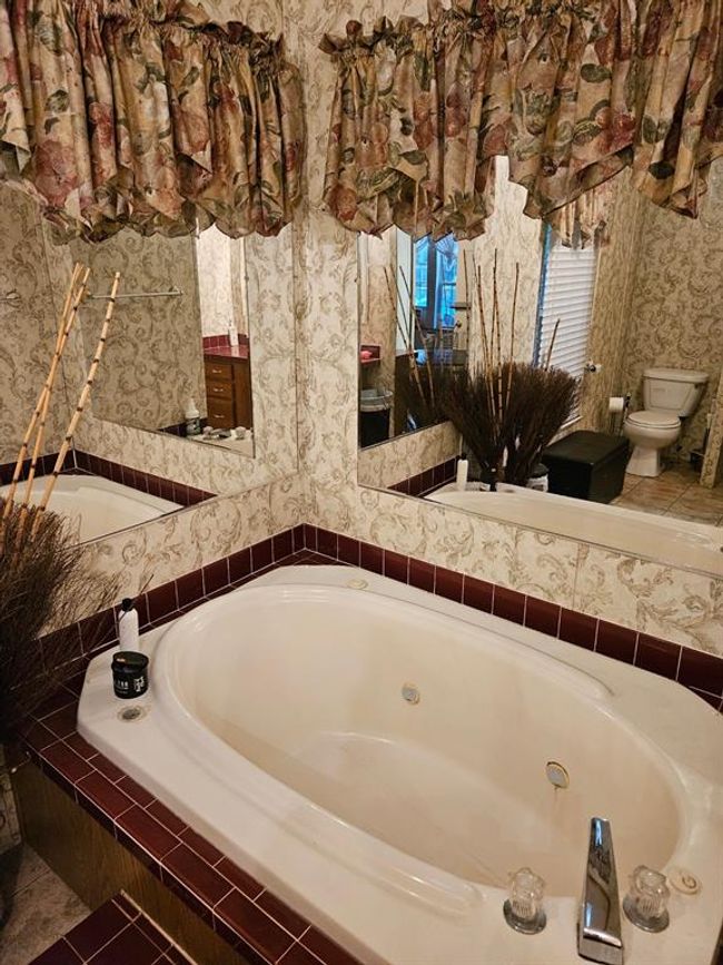 Bathroom featuring tiled tub, tile patterned floors, and toilet | Image 35