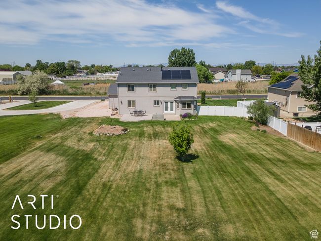 Back of property with roof mounted solar panels, a patio area, and a residential view | Image 47