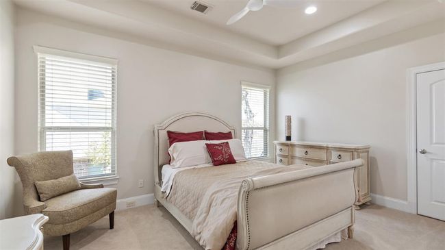 Secondary upstairs bedroom features tray ceiling and a large walk-in closet. | Image 42