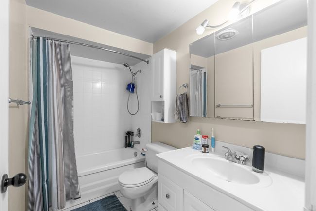 Bathroom featuring toilet, shower / bathtub combination with curtain, and vanity | Image 16