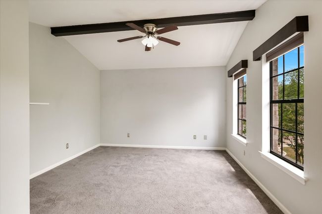 A high ceiling with a center beam ties in with the custom window valances. | Image 10