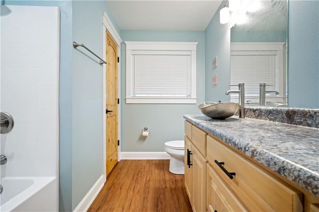 Full bath featuring toilet, vanity, shower combination, wood finished floors, and baseboards | Image 24
