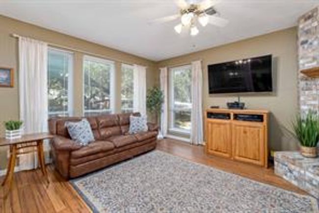 Living area with a ceiling fan and wood finished floors | Image 10
