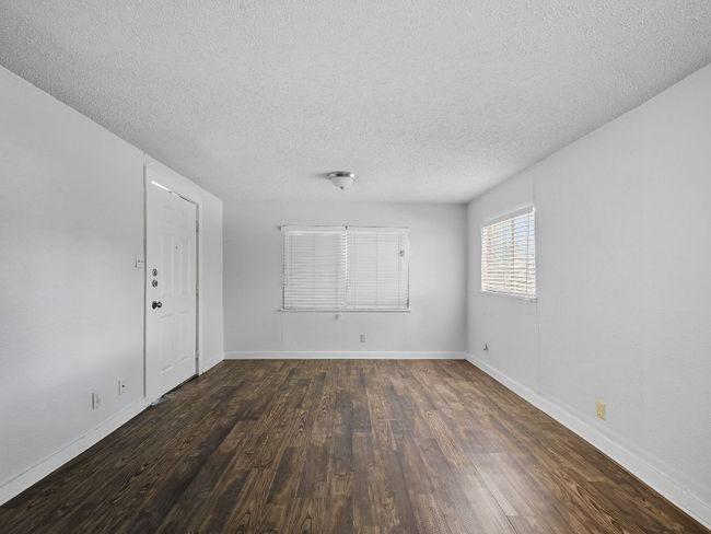 Unfurnished room with dark wood-style floors and a textured ceiling | Image 14