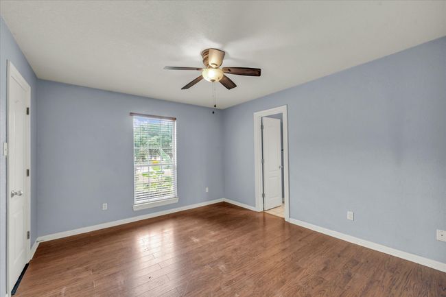 Empty room with a ceiling fan and wood finished floors | Image 26