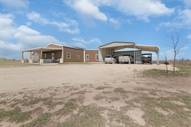 Rear view of house with a detached carport and driveway | Image 4