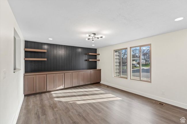 Unfurnished room with visible vents, baseboards, wood finished floors, recessed lighting, and an inviting chandelier | Image 4