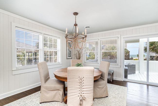 Dining area with wood finished floors, a notable chandelier, and a healthy amount of sunlight | Image 8