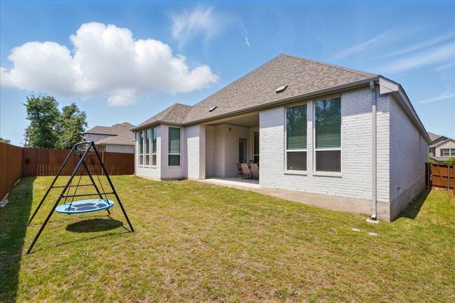 Rear view of property with brick siding, a patio, a playground, and a shingled roof | Image 31