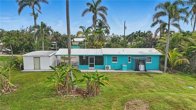 Back of property with a sunroom, a yard, a shed, and a metal roof | Image 35