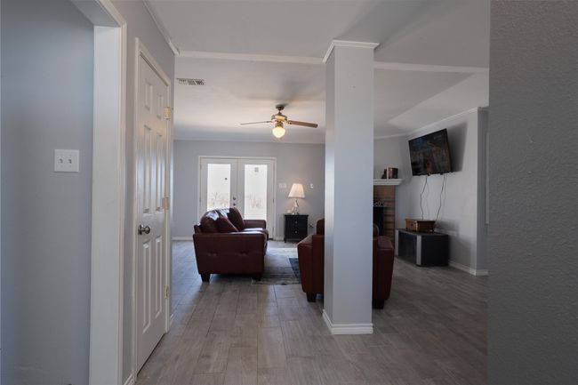 Hall with wood finished floors, baseboards, and ornamental molding | Image 4
