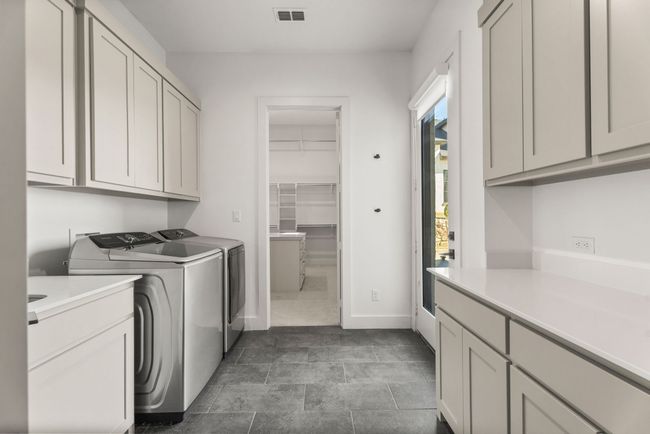 Laundry room with baseboards, cabinet space, visible vents, and separate washer and dryer | Image 32