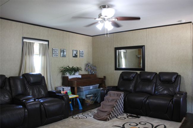 Living room featuring a ceiling fan and wood finished floors | Image 29