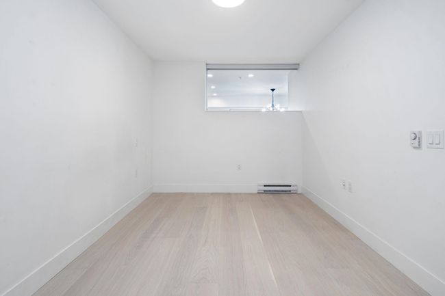 Unfurnished room with a baseboard radiator, baseboards, and wood finished floors | Image 15