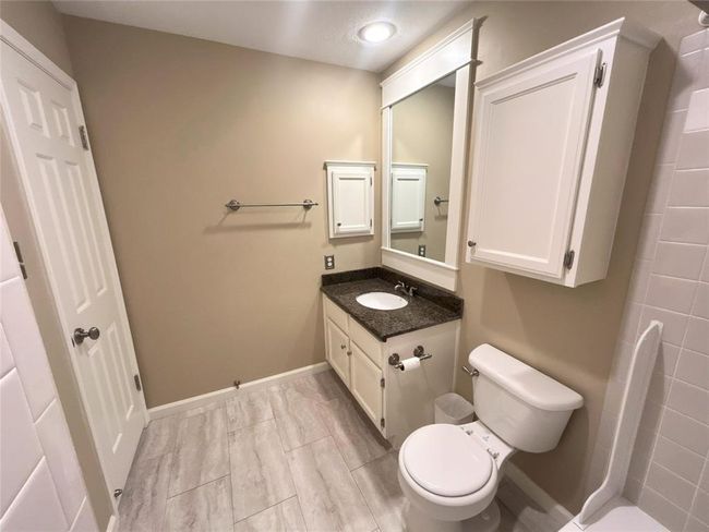 The Jack and Jill bathroom has a framed mirror, granite countertops, overhead storage and two entries (one is a little hidden in this photo by the wall bump out on the left). | Image 33