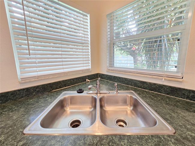 Kitchen sink with windows overlooking fenced back yard | Image 21