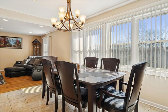 Dining room with light tile patterned floors, recessed lighting, baseboards, and a chandelier | Image 19
