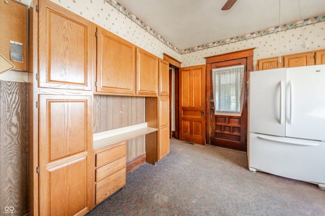 kitchen with ceiling fan, freestanding refrigerator, light carpet, and wallpapered walls | Image 9