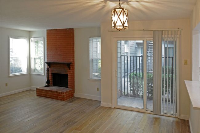 Doorway to outside with a fireplace, a chandelier, and Luxury Vinyl Plank floors | Image 11