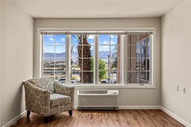 Sitting room with a mountain view, wood finished floors, a wall mounted AC, and baseboards | Image 10