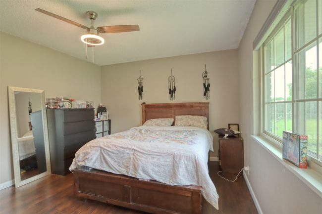 Bedroom with wood finished floors and ceiling fan | Image 39