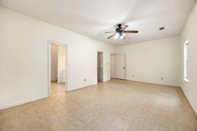 This oversized primary bedroom has upgraded lighting and tile flooring. | Image 25