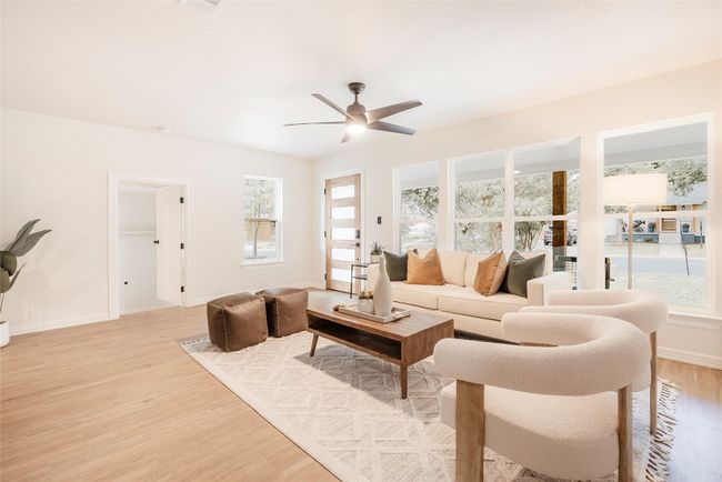 Living area with light wood-style floors, a ceiling fan, and plenty of natural light | Image 6