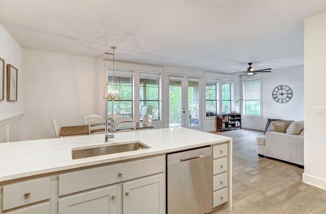 Kitchen featuring dishwasher, a sink, light wood finished floors, light countertops, and a ceiling fan | Image 10
