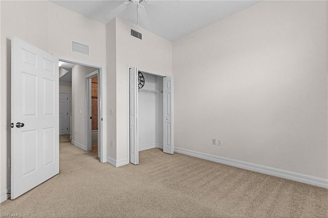 Unfurnished bedroom featuring light carpet, a closet, ceiling fan, and a high ceiling | Image 16