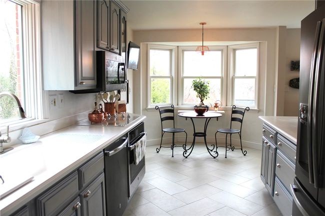 Natural Light streams through this lovely kitchen w/SS Appliance, Corian Countertops and breakfast Nook | Image 14