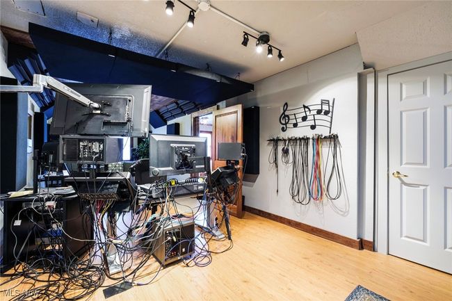 Miscellaneous room with rail lighting, baseboards, and wood finished floors | Image 9