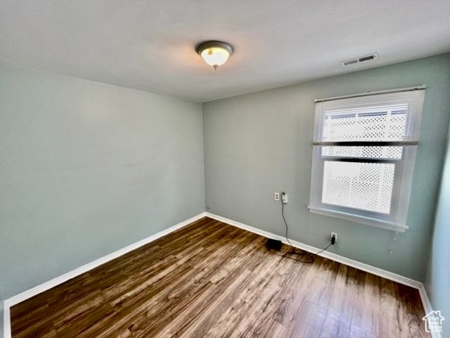 Spare room featuring dark wood-type flooring, visible vents, and baseboards | Image 6