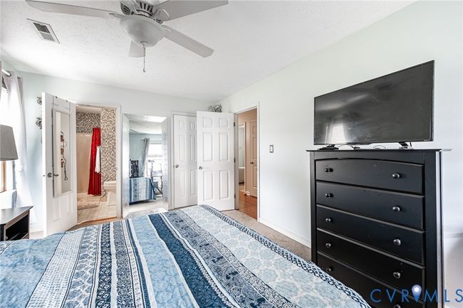 Bedroom with connected bathroom, a textured ceiling, and ceiling fan | Image 18