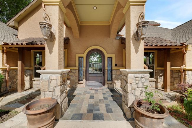 Property entrance with stone siding, stucco siding, and a tile roof | Image 4