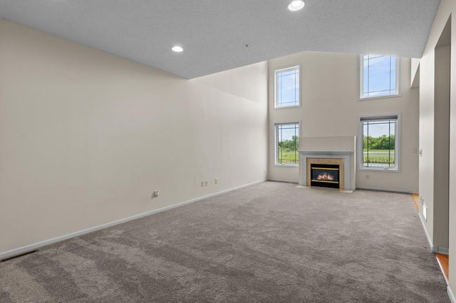 The windows flood the living area with natural light and pond views. | Image 6