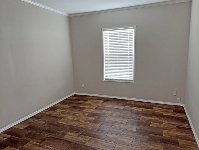 Spare room with dark wood-style flooring and ornamental molding | Image 24