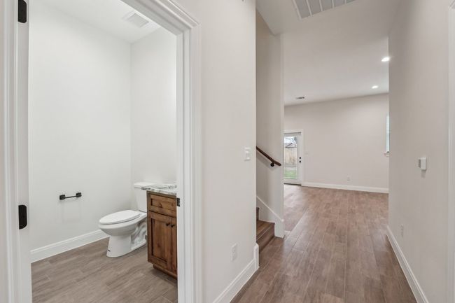 Half bathroom with visible vents, toilet, baseboards, and wood plank tile floor | Image 24
