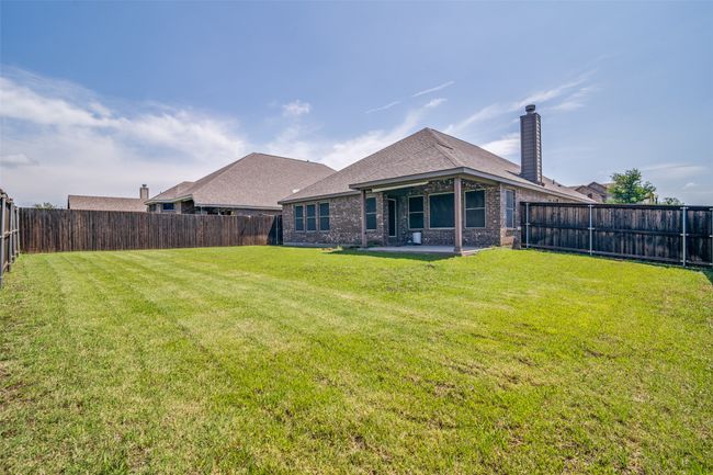 Rear view of house featuring a patio, a fenced backyard, and brick siding | Image 23