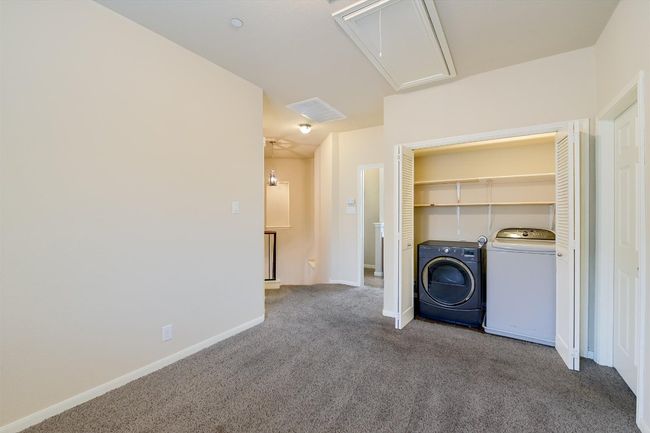 Laundry room featuring attic access, washer and clothes dryer, and carpet flooring | Image 13
