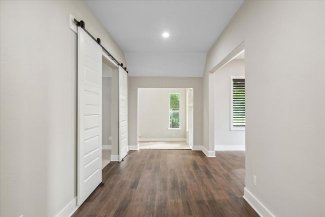 Hall featuring a barn door, dark wood-style flooring, baseboards, and recessed lighting | Image 7